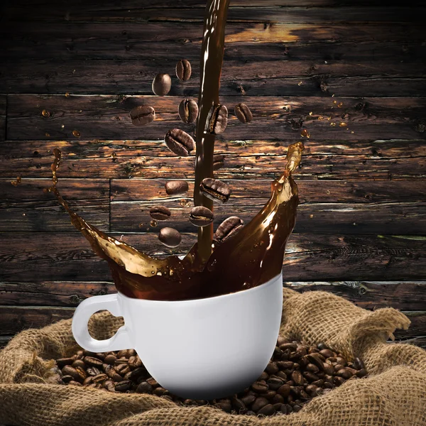 Chicchi di caffè che cadono in tazza di caffè caldo — Foto Stock