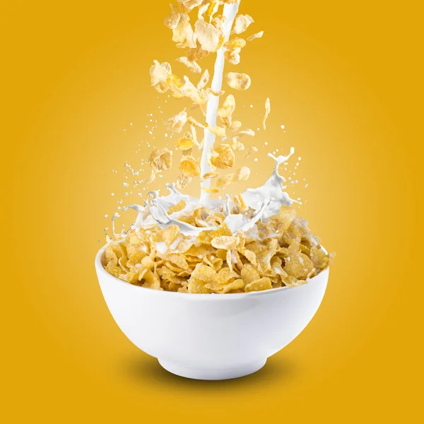Flocos de milho e salpicos de leite na tigela — Fotografia de Stock