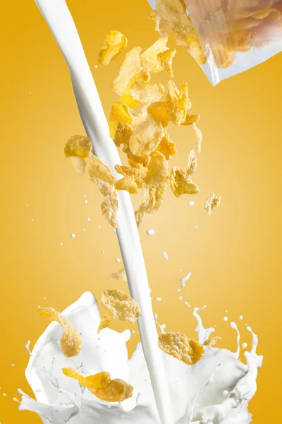 Copos de maíz cayendo en la salpicadura de leche —  Fotos de Stock