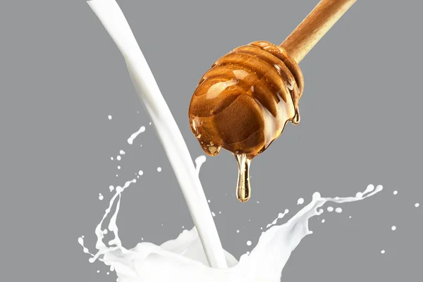 Gocciolamento di miele nel latte — Foto Stock