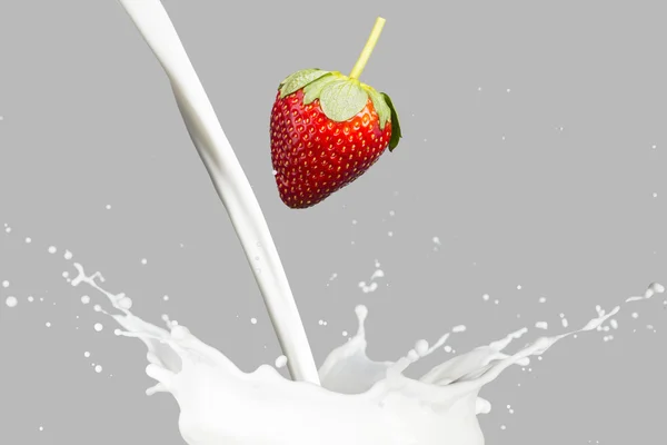 Fresas cayendo en el chorro de leche — Foto de Stock