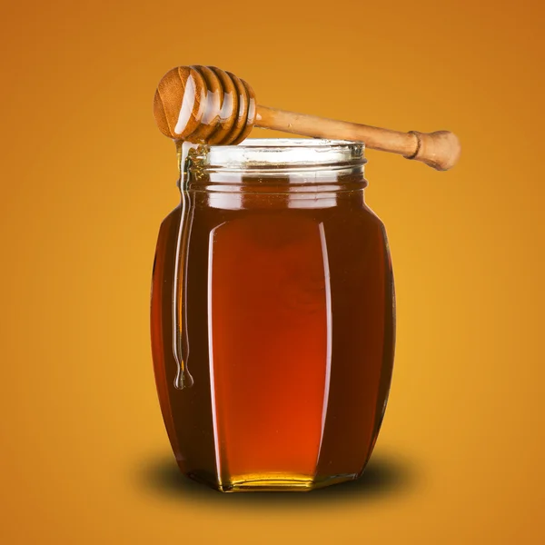 Honey dipper on jar of honey — Stock Photo, Image