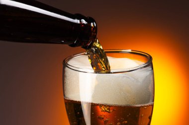 Siyah arka planda köpüklü soğuk bira şişesi..