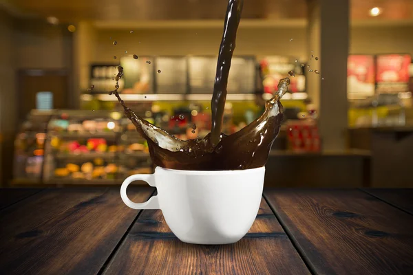 Café vertiendo en la taza con salpicadura —  Fotos de Stock