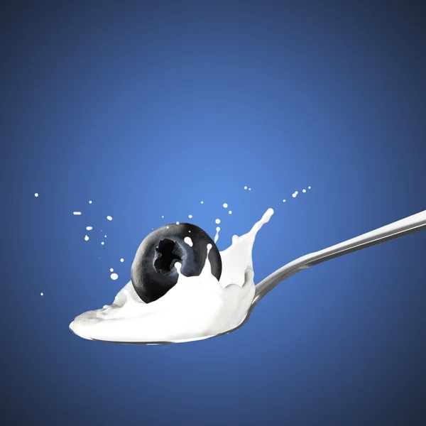 Голубика, падающая в молоко — стоковое фото