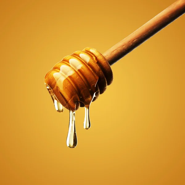 Gocciolamento di miele su bianco — Foto Stock