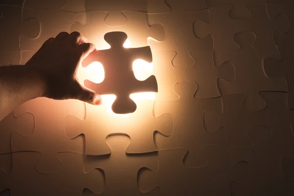 Hand holding jigsaw puzzle piece — Stock Photo, Image