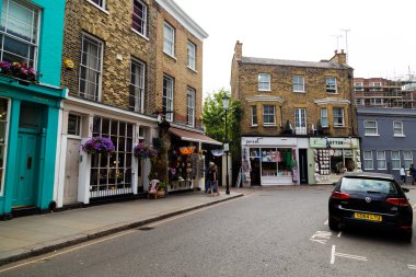 LONDON, İngiltere - 16 Temmuz 2015: Gündüzleri Londra 'da Portobello Yolu boyunca binaların ve dükkanların manzarası. İnsanlar görülebilir..