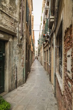 VENICE, İtalya - 13 Mart 2015: Venedik 'teki dar sokaklar boyunca eski binaların dışını gösteren bir manzara