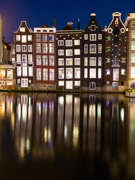 Budynki wzdłuż Damrak nocą w Amsterdamie — Zdjęcie stockowe