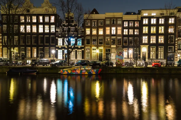 Canali ad Amsterdam di notte e una barca colorata — Foto Stock