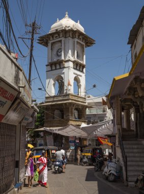 UDAIPUR, INDIA - 20 Mart 2016: Udaipur şehir merkezindeki Ghanta Ghar Saat Kulesi. İnsanlar sokak boyunca görülebilir..