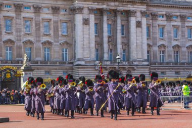 LONDON, UK - 24TH MARCH 2014: The Queens Guards musicians coming out of Buckingham Palace during the Changing of the Guard clipart