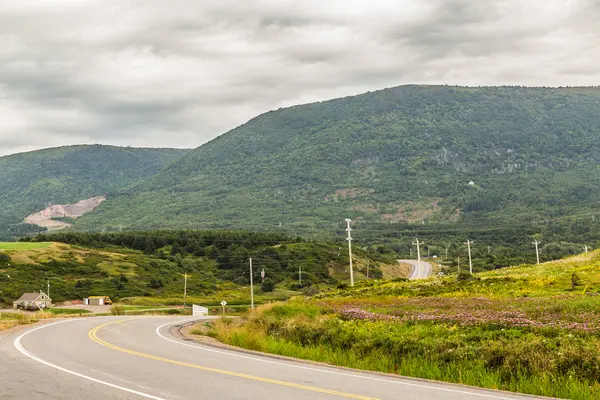 CAPE BRETON, CANADA - 27TH AUGUST 2015: Cape Breton Island in Nova Scotia during the day showing hills and a bendy road.