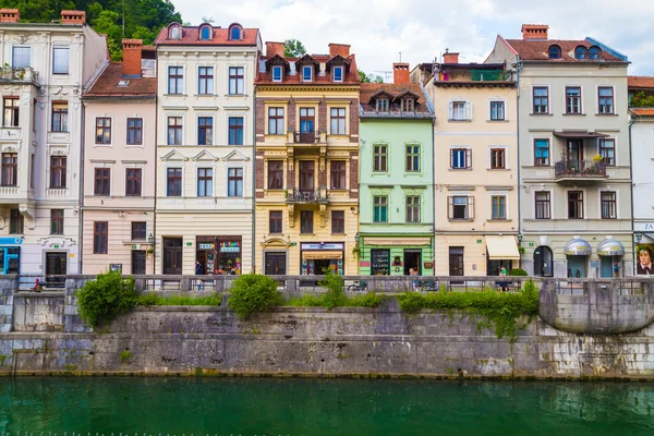 Verschillende gebouwen in Ljubljana langs de rivier. — Stockfoto