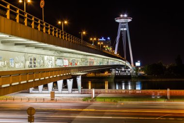 BRATISLAVA, SLOVAKIA - 29 Nisan 2016: Geceleri UFO Kulesi ve Novy Most Köprüsü. UFO Kulesi şehrin yüksek manzarasını sunar,