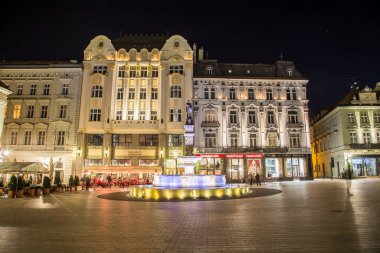 BRATISLAVA, SLOVAKIA - 29 Nisan 2016: Eski Şehir Bratislava 'daki binalar ve Maximilian Çeşmesi manzarası. İnsanlar ve restoranların dışı görülebilir..