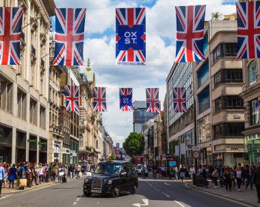 LONDON, İngiltere - 28 Haziran 2016: Gün boyunca Londra 'da Oxford Caddesi boyunca bir manzara. Siyah bir Londra taksisi, sendika bayrakları ve bir sürü insan görülebilir..