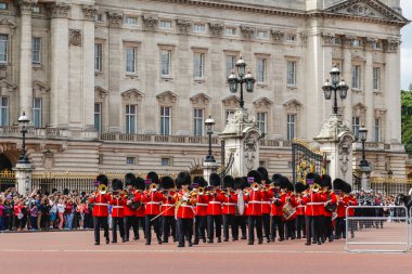 LONDON, İngiltere - 28 Haziran 2016: Yazın Buckingham Sarayı 'nda düzenlenen Muhafız Değişim Töreni sırasında Alay Grubu' ndan müzik desteği. Askerler kırmızı ceketler ve ayı postu şapkaları giyerken görülebilir.