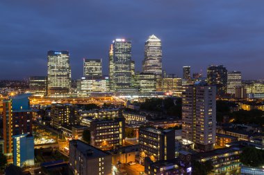 Londra, İngiltere - 28 Haziran 2016: Geceleri Canary Wharf 'a doğru bir manzara. Apartman binaları ön planda görülebilir..