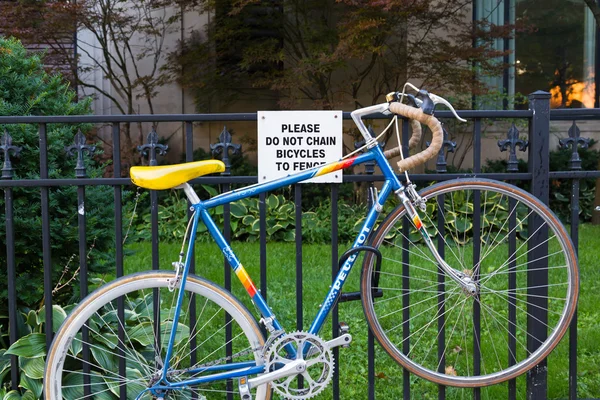 Bicicleta acorrentada a uma cerca — Fotografia de Stock