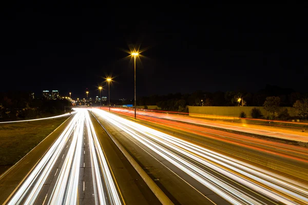 Trilhas de luz em uma estrada — Fotografia de Stock