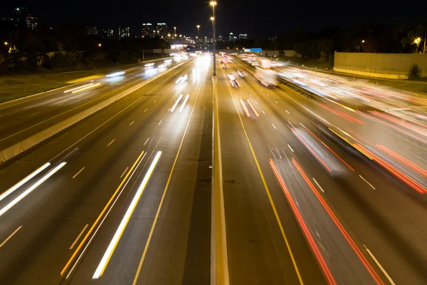 Trilhas de luz curtas em uma estrada — Fotografia de Stock