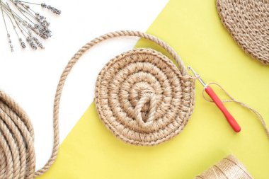 Beyaz ve yeşil arka planda Haziran sepeti örmek, hobi. Düz yatış stili. Jute tığ işi kavramı.