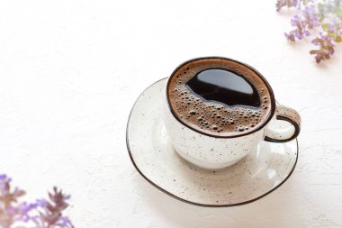 Beyaz desenli kahve fincanı, kır çiçekleri, rahatlama konsepti..