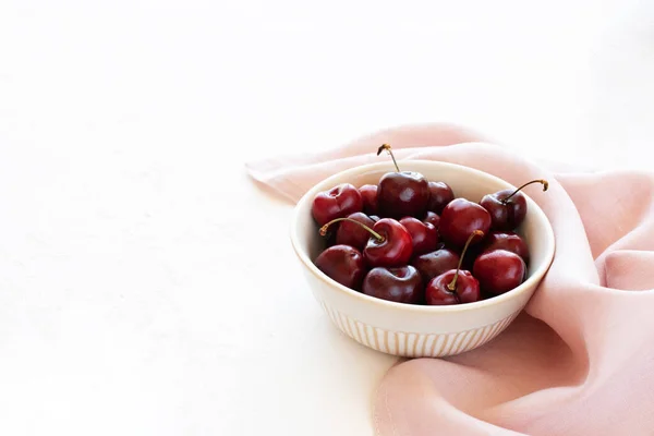 Cerises Crues Dans Bol Sur Une Serviette Rose Fond Blanc — Photo