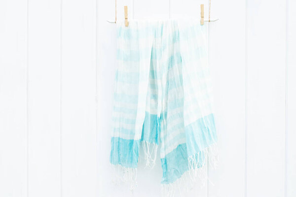 Beautiful summer scarf on white wooden wall, boho style and minimalism concept. Place for text.