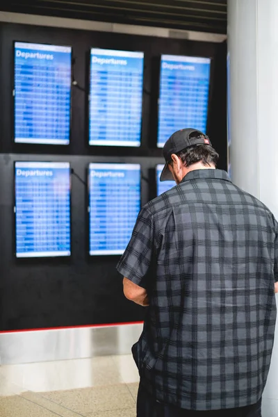 Mężczyzna Tyłu Przed Wylotami Ekranów Informacyjnych Lotnisku Usa — Zdjęcie stockowe