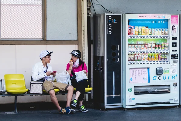 Tokio Japón Joven Pareja Japonesa Esperando Comiendo Sillas Amarillas Vía —  Fotos de Stock