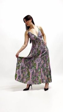 Stüdyo çekiminin sahne arkasında esmer model fotoğrafçı ve stilist için poz veriyor.