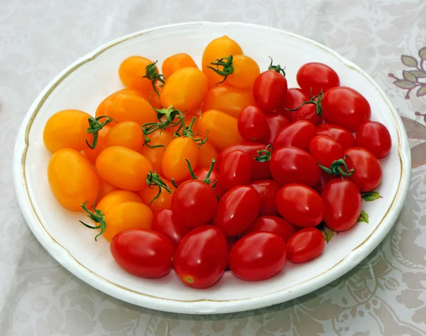 Cherry tomatoes red and yellow on a plate — Stock Photo, Image