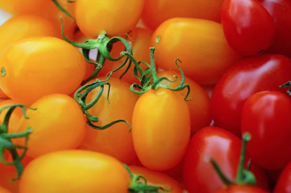 Kırmızı ve sarı arka plan olarak kiraz domates — Stok fotoğraf