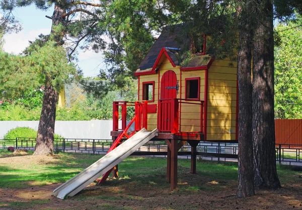 Яркий детский деревянный дом с горкой Лицензионные Стоковые Изображения