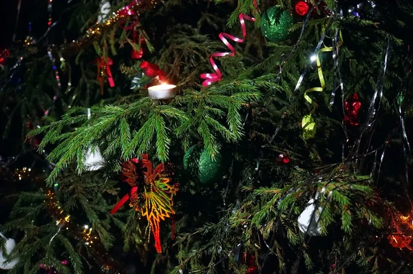 Рождественская елка украшена свечами, лентами, игрушками крупным планом — стоковое фото