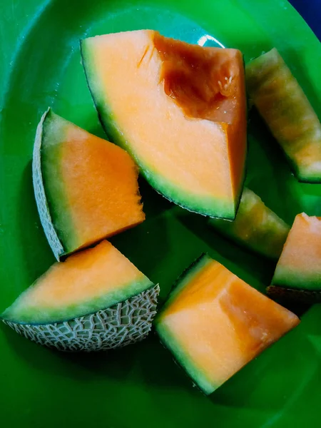 Yellow melon slice on the green plate