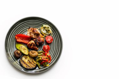 Tabakta ızgara sebzeli tavuk şişi. İçinde et ve sebze olan bir kase. Diyet yemeği. Piknik. Beyaz bir arka planda yemek tabağı. Sebzeli ızgara et..