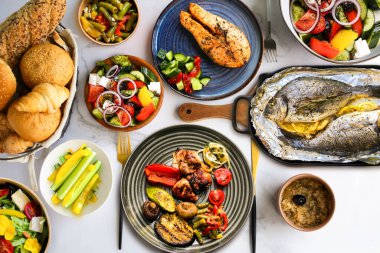 Bir sürü sağlıklı yiyecek var. Düzgün beslenme. Tabağında yemek olan bir masa, manzaralı. Sağlıklı yemek tabaklarının üst görüntüsü. Çeşitli büfeler. Sağlıklı yemek. Salatalı somon bifteği, ızgara sebze ve tabakta et..