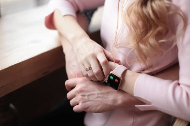 Ellerine dikkat et. Saat başı ara. Telefona gelen arama nöbette gösteriliyor. İş adamı saati işaret ediyor. El ele tutuşan kol saati. Arıyorum. Sarılalım.