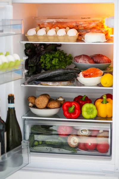 Full fridge of healthy food. Proper nutrition. The keto diet. Refrigerator with healthy food. Products in the refrigerator. Meat with vegetables. The concept of proper nutrition. Fish, red fish in the refrigerator, salmon, Seabass.
