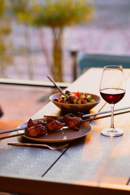 Şişte kızarmış et, tabakta kebap, bir bardak kebap ve bir bardak şarapla birlikte kebap, terasta şarap ve etle akşam yemeği. Akşam yemeği için kızarmış et. Akşam yemeği.