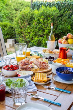 Terasta yemekli bir masa. Büyük bir aile için bir yemek masası. Bir parti. Yaz terasında bir akşam yemeği. Sokakta bir doğum günü..