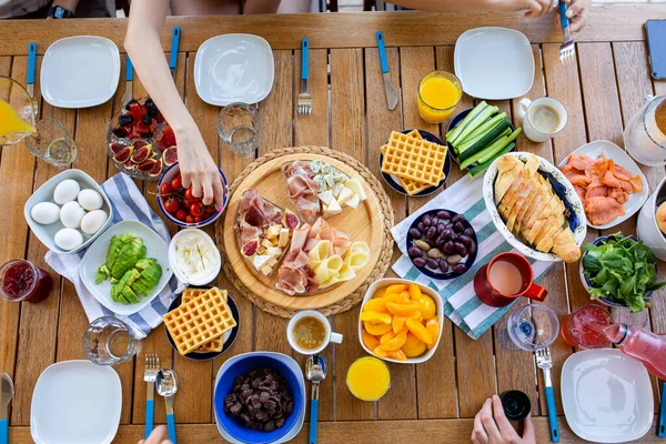 Beautiful breakfasts on the table top view. Large table with food top view. Table with food and people\'s hands. People have breakfast at the table top view.Beautiful breakfast for a large family. Breakfast constructor. Dinner