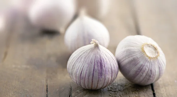 Bulbos de ajo en una superficie de madera — Foto de Stock