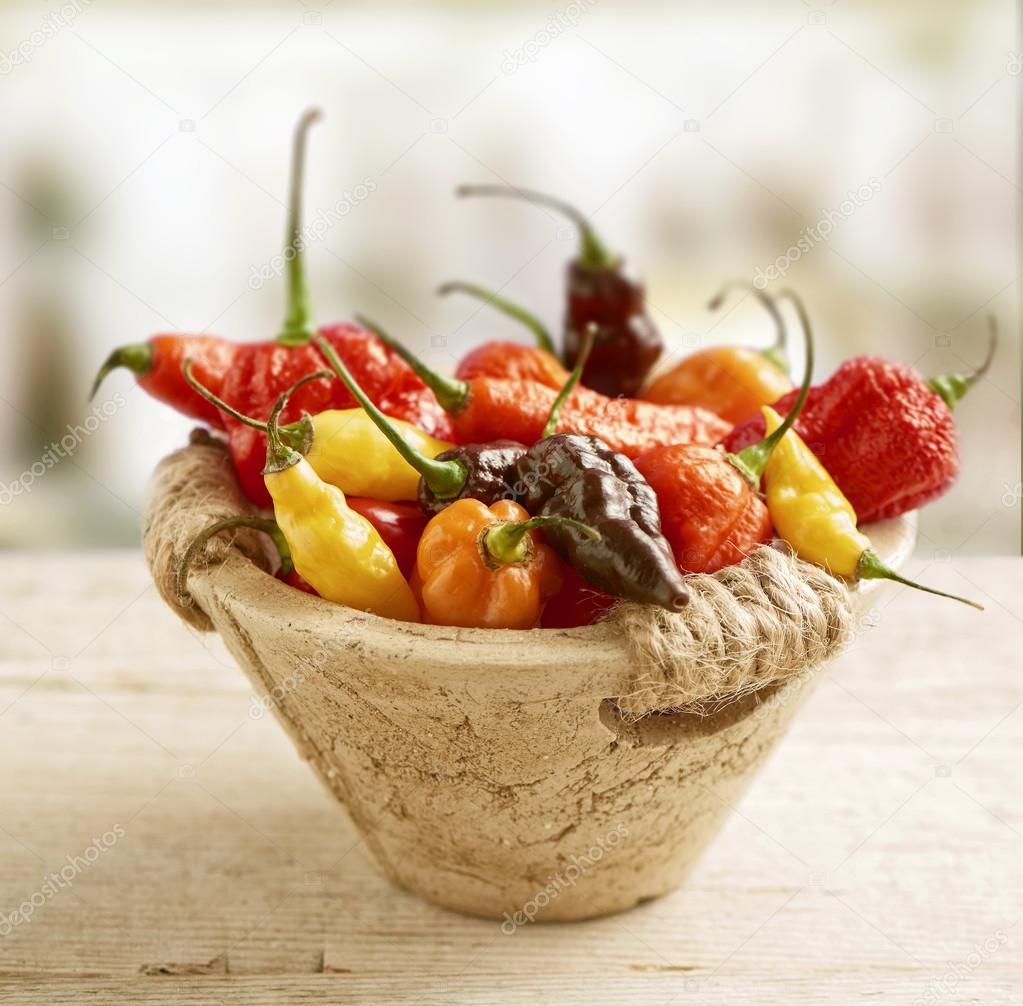 Hot pepper mix photographed in a stone basket Stock Photo by