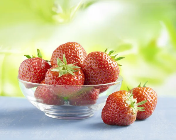 Erdbeeren in einer Glasschüssel auf einem Tisch draußen lizenzfreie Stockfotos