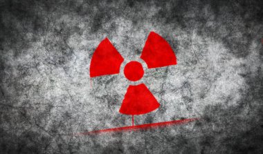 Radyasyon ve nükleer enerji uyarı sembolü beton duvara boyanmış. Radyoaktif tehlike ve tehlike graffiti konsepti sanatı. Elinde işaret şablonu olan bir boya. Şehir soyut sanat eserleri.